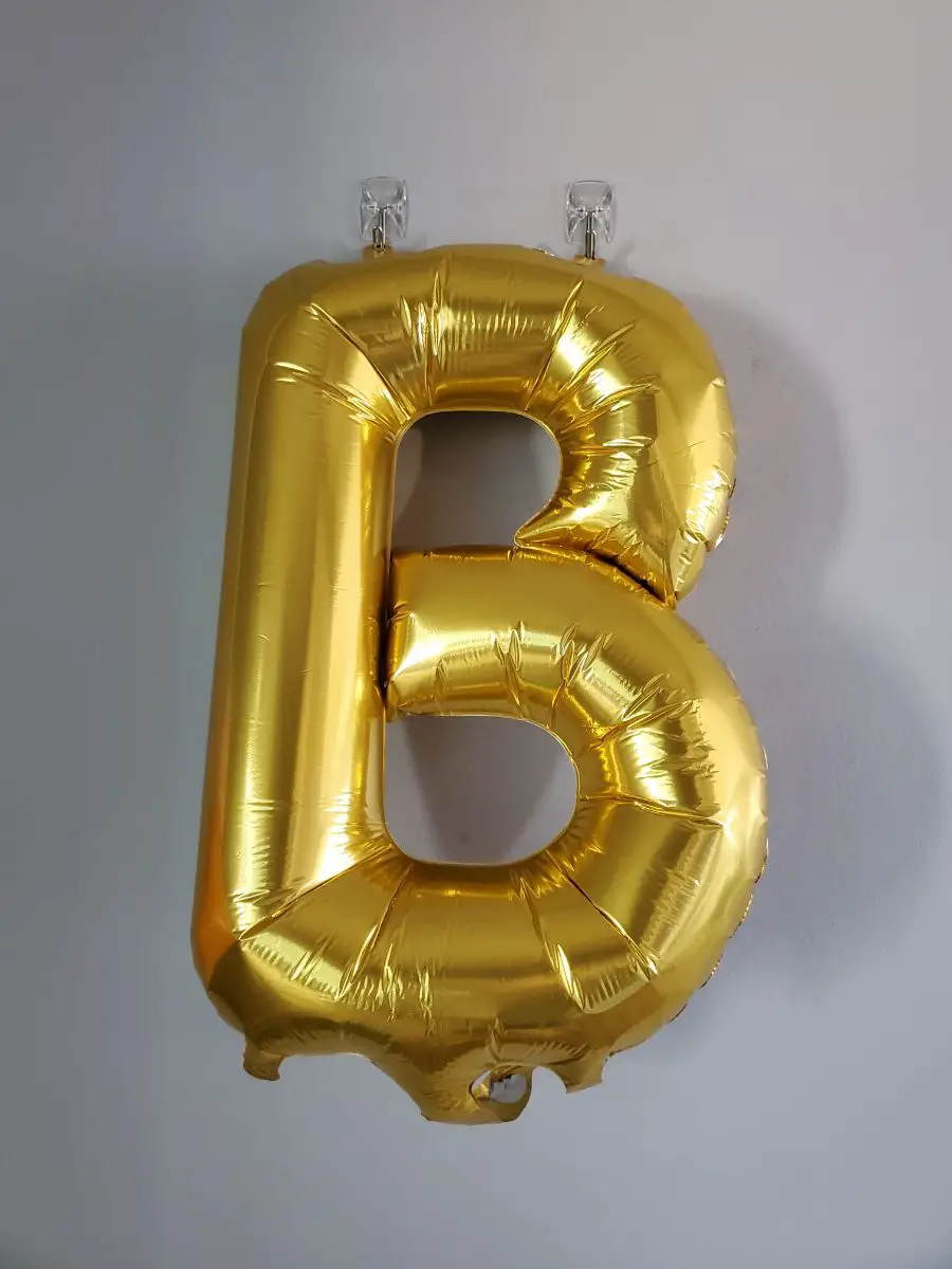 Foil balloon hanging on wall with hooks