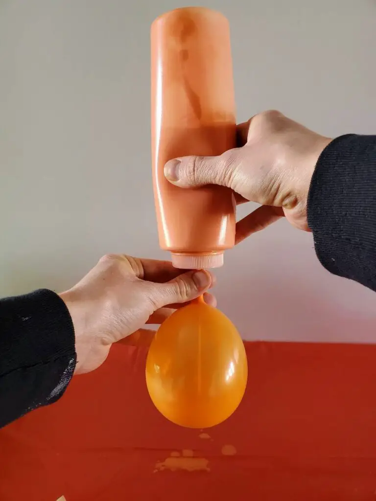 Filling an Inflated Balloon with Orange Paint